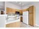 Well-lit kitchen with classic wood cabinets, white appliances, and neutral mosaic backsplash at 8475 Pebble Creek Way # 204, Highlands Ranch, CO 80126