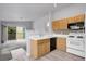 Modern kitchen with white appliances, stylish backsplash, and convenient breakfast bar overlooking living area at 8475 Pebble Creek Way # 204, Highlands Ranch, CO 80126