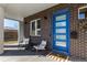 Charming front porch with a blue door, brick facade, and comfortable seating at 4335 N Pecos St, Denver, CO 80211