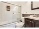 Modern bathroom featuring a tiled shower with glass door and wood vanity with sink at 2111 W 80Th Ave, Denver, CO 80221