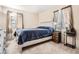 Comfortable bedroom with neutral tones, a bed with a blue blanket, and bedside tables at 2111 W 80Th Ave, Denver, CO 80221
