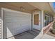Attached garage featuring a white door and adjacent entry door with brick accents at 2111 W 80Th Ave, Denver, CO 80221