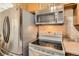 Close up of modern kitchen appliances including a stove, microwave, and refrigerator at 2111 W 80Th Ave, Denver, CO 80221
