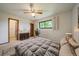 Bedroom featuring a ceiling fan, neutral decor, a large window, carpeted floors and an ensuite bathroom at 14735 W Ellsworth Ave, Golden, CO 80401
