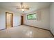 Spacious main bedroom features a ceiling fan, neutral decor, a large window, and carpeted floors at 14735 W Ellsworth Ave, Golden, CO 80401