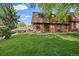 Charming brick townhouse with a well-maintained lawn and mature trees, offering a peaceful outdoor setting at 14735 W Ellsworth Ave, Golden, CO 80401