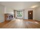 Cozy living room featuring hardwood floors, a brick fireplace, and a bright window at 14735 W Ellsworth Ave, Golden, CO 80401