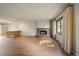 Bright living room featuring hardwood floors, a brick fireplace, and a window with natural light at 14735 W Ellsworth Ave, Golden, CO 80401