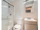 This bathroom features a shower with glass door, vanity, mirror, and neutral walls at 6032 Estes St, Arvada, CO 80004