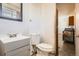 This bathroom features a vanity, toilet, and a view into the kitchen at 6032 Estes St, Arvada, CO 80004