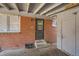 Enclosed patio area with brick wall, door, windows, and covered ceiling; potential for outdoor living at 6032 Estes St, Arvada, CO 80004