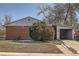 Charming single-story brick home featuring a carport and mature landscaping under a clear, blue sky at 6032 Estes St, Arvada, CO 80004