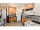 Functional kitchen featuring wooden cabinets, laminate counters, and potential for customization at 6032 Estes St, Arvada, CO 80004