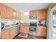 Well-lit kitchen featuring stainless steel appliances, light wood cabinets, and ample counter space at 2911 S Olathe Way, Aurora, CO 80013