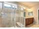 Bright bathroom featuring dual sinks, a large mirror and walk-in shower with glass doors at 19820 W 57Th Ln, Golden, CO 80403