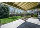 Covered patio area looking out to a green backyard with mature trees and landscaping at 12154 W Exposition Dr, Lakewood, CO 80228
