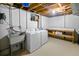 Basement laundry area with washer, dryer, utility sink, and work bench at 12154 W Exposition Dr, Lakewood, CO 80228