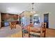 Open dining area with hardwood floors, views into the kitchen, and a stylish chandelier at 12154 W Exposition Dr, Lakewood, CO 80228