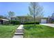 Charming home featuring a well-manicured front yard, lush lawn, and a welcoming walkway leading to the front door at 12154 W Exposition Dr, Lakewood, CO 80228