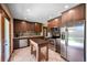 Modern kitchen featuring stainless steel appliances, dark wood cabinets, and an island for meal prep at 12154 W Exposition Dr, Lakewood, CO 80228