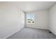 This bedroom features neutral carpet, a door, one window, and fresh white walls at 1080 Joseph Pl, Erie, CO 80026