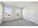 The bedroom includes neutral carpet, a door, two windows, and fresh white walls at 1080 Joseph Pl, Erie, CO 80026