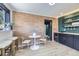 Charming dining area with brick accent wall, modern lighting, and a stylish table with seating at 6876 Quay Ct, Arvada, CO 80003