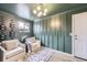 This cozy sitting room features stylish green walls, a modern light fixture, and comfortable seating with a decorative wine rack at 6876 Quay Ct, Arvada, CO 80003