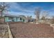 Expansive backyard with mulched garden beds, patio, sunroom, and exterior of the home at 16463 E Girard Ave, Aurora, CO 80013