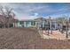 View of home's rear exterior with a mulched yard, patio with gym equipment, and a shed at 16463 E Girard Ave, Aurora, CO 80013