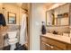 Well-lit bathroom with a wood vanity, a decorative mirror, and a tiled shower at 16463 E Girard Ave, Aurora, CO 80013