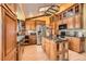 Kitchen with stainless steel appliances, island, wood cabinetry, and light hardwood floors at 16463 E Girard Ave, Aurora, CO 80013