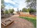 Spacious backyard with shed, garden beds, fire pit, mature trees, and wood fence at 357 Saturn Pl, Lone Tree, CO 80124