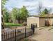 View of backyard with shed, lawn area, garden beds, and black metal fence at 357 Saturn Pl, Lone Tree, CO 80124