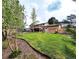 Expansive backyard featuring a well-maintained lawn, a spacious deck, and mature trees at 357 Saturn Pl, Lone Tree, CO 80124
