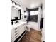 Bathroom featuring wood flooring, white cabinets with black handles, and a shower/tub at 357 Saturn Pl, Lone Tree, CO 80124