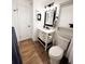 Bathroom featuring wood flooring, white cabinets with black handles, and a toilet at 357 Saturn Pl, Lone Tree, CO 80124