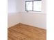 Cozy room features wood-look flooring, base trim, and a bright window at 357 Saturn Pl, Lone Tree, CO 80124