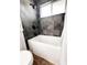 A shower and tub featuring gray tile and a white tub at 357 Saturn Pl, Lone Tree, CO 80124