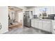 Modern kitchen with stainless steel appliances and gray backsplash, adjacent to the dining area at 932 Quentin St, Aurora, CO 80011