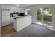Well-lit kitchen with white cabinets, modern appliances, breakfast bar, and access to outdoor deck at 7604 S Steele St, Centennial, CO 80122
