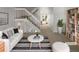 Bright living room featuring contemporary furnishings, a stylish rug, and a view of the staircase at 7604 S Steele St, Centennial, CO 80122