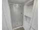 Tiled shower with sliding glass door and built-in shelving, features a clean design at 7604 S Steele St, Centennial, CO 80122
