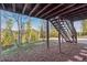 Backyard view under wooden deck with access to the driveway and the surrounding woods at 9790 City View Dr, Morrison, CO 80465