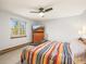 Bright bedroom with a colorful striped blanket, ceiling fan, and window with a scenic view at 9790 City View Dr, Morrison, CO 80465