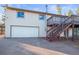 Exterior view of a two-story house with a white garage and stairs leading to a deck at 9790 City View Dr, Morrison, CO 80465