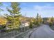House exterior with a paved driveway and lush trees and yard at 9790 City View Dr, Morrison, CO 80465