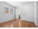 Light-filled bedroom with hardwood floors and neutral walls with an ensuite bathroom at 2140 S Washington St, Denver, CO 80210
