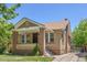 Charming brick home featuring a covered front porch and well-maintained landscaping at 2140 S Washington St, Denver, CO 80210