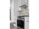 Modern kitchen features stainless steel oven, stone backsplash, and white cabinets at 2140 S Washington St, Denver, CO 80210